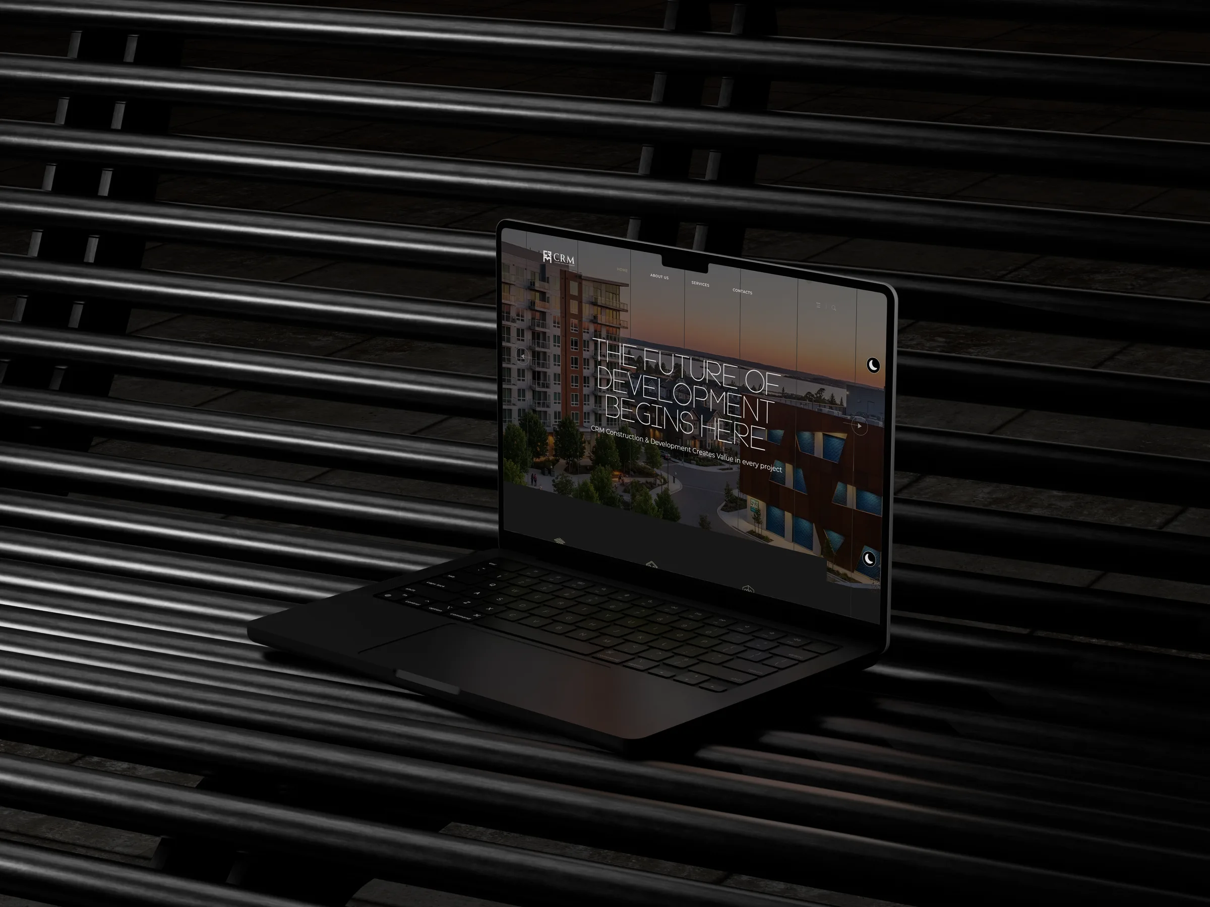 CRM Construction and Development site on a laptop over dark steel slats